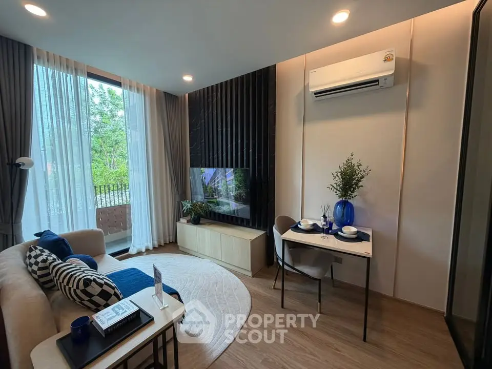 Modern living room with stylish decor, large window, and cozy seating area.