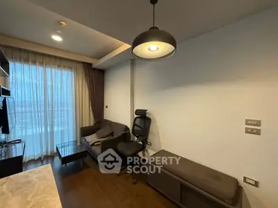 Modern living room with stylish furniture and large window offering natural light.