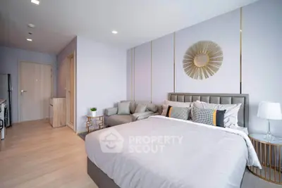 Modern bedroom with stylish decor and cozy seating area in a contemporary apartment.