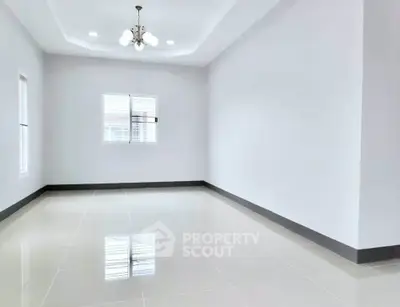 Spacious empty room with elegant chandelier and glossy tiled floor, perfect for customization.