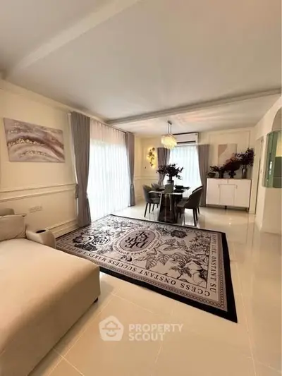 Elegant living room with stylish decor and dining area, featuring large windows and modern furnishings.