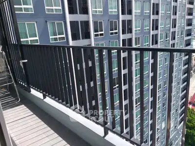 Modern high-rise building view from balcony with sleek railing design.