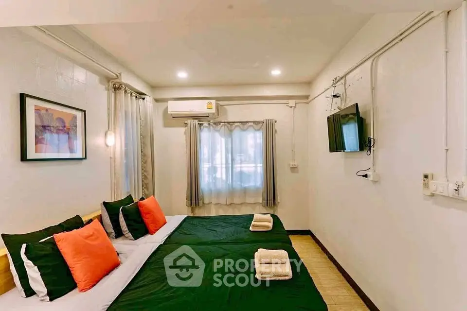 Cozy bedroom with modern decor, featuring twin beds and wall-mounted TV.