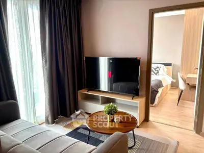 Modern living room with sleek TV and cozy bedroom view, perfect for urban living.