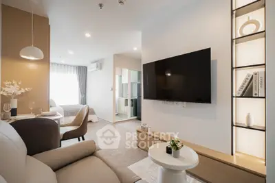 Modern living room with sleek TV setup and cozy seating area in stylish apartment.