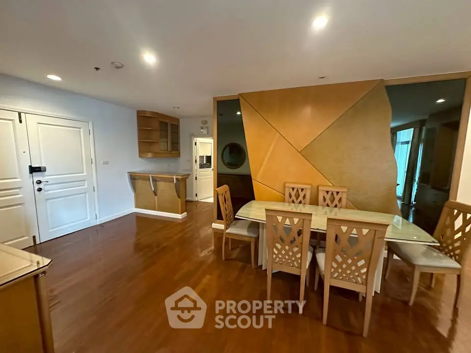 Spacious dining area with elegant wooden flooring and modern furniture in a stylish apartment.