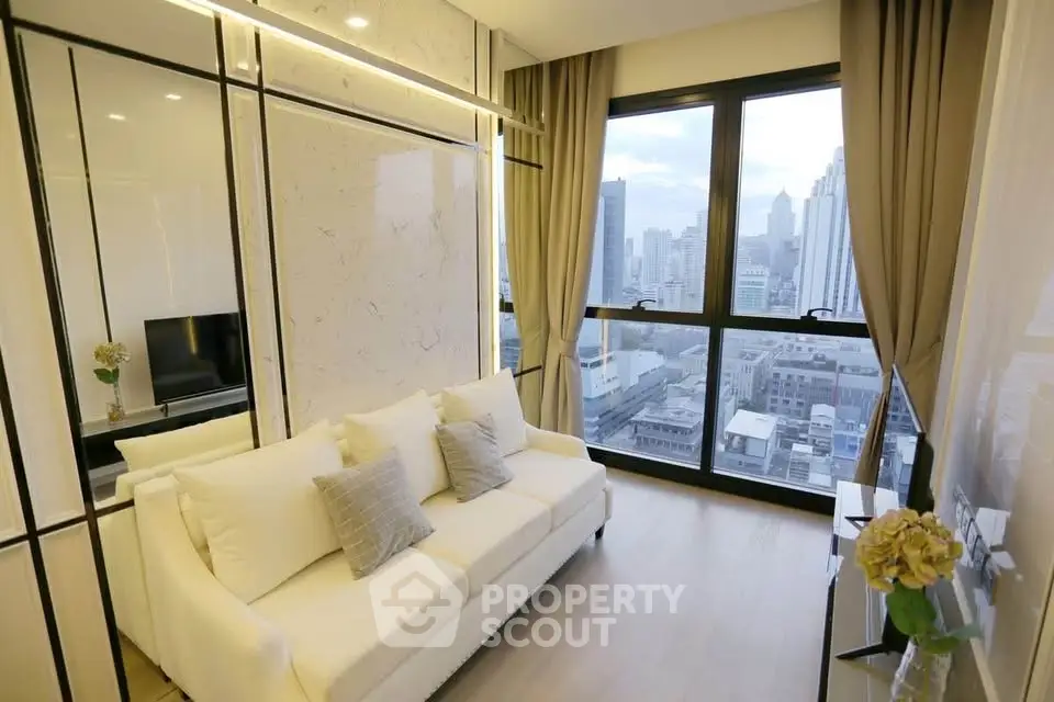 Modern living room with city view, elegant decor, and large windows in a high-rise apartment.