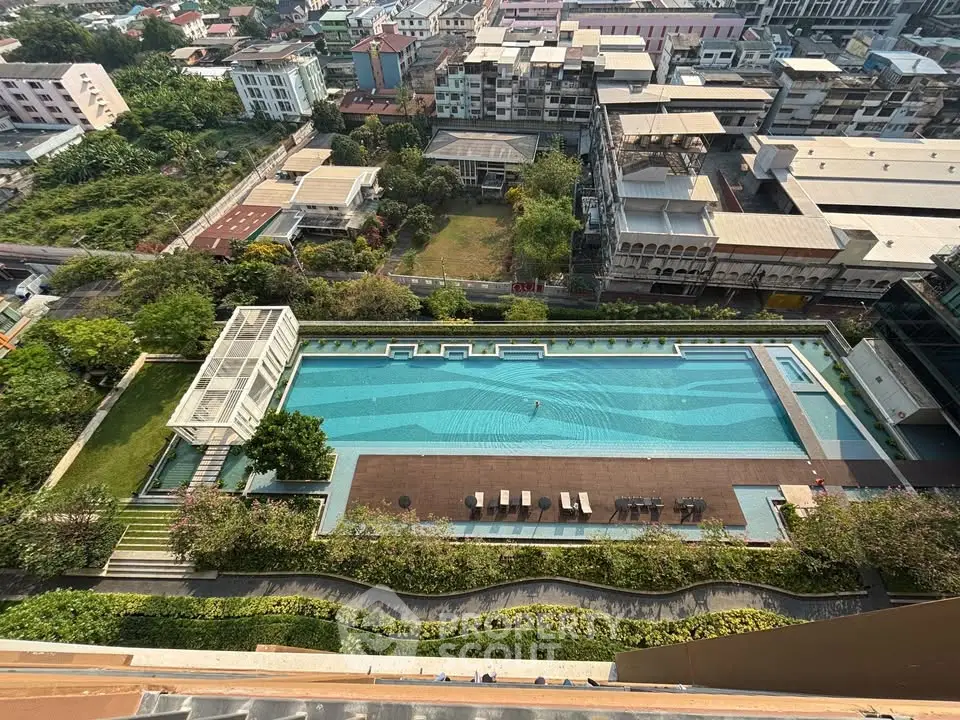 Stunning aerial view of a luxurious residential pool with surrounding cityscape.