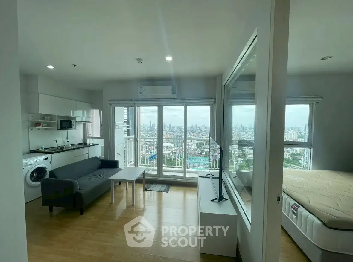 Modern studio apartment with city view, featuring open layout and sleek furnishings.