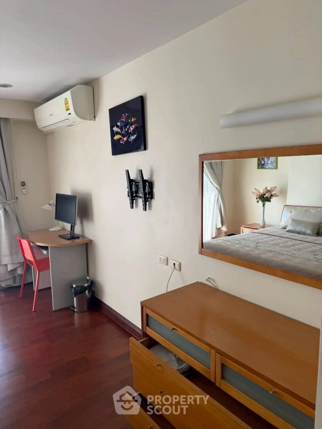 Cozy bedroom with desk, air conditioning, and wooden furniture, perfect for a comfortable living space.