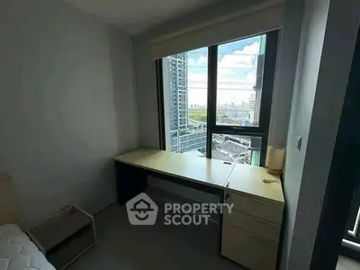 Modern study room with city view, featuring a sleek desk and large window for natural light.