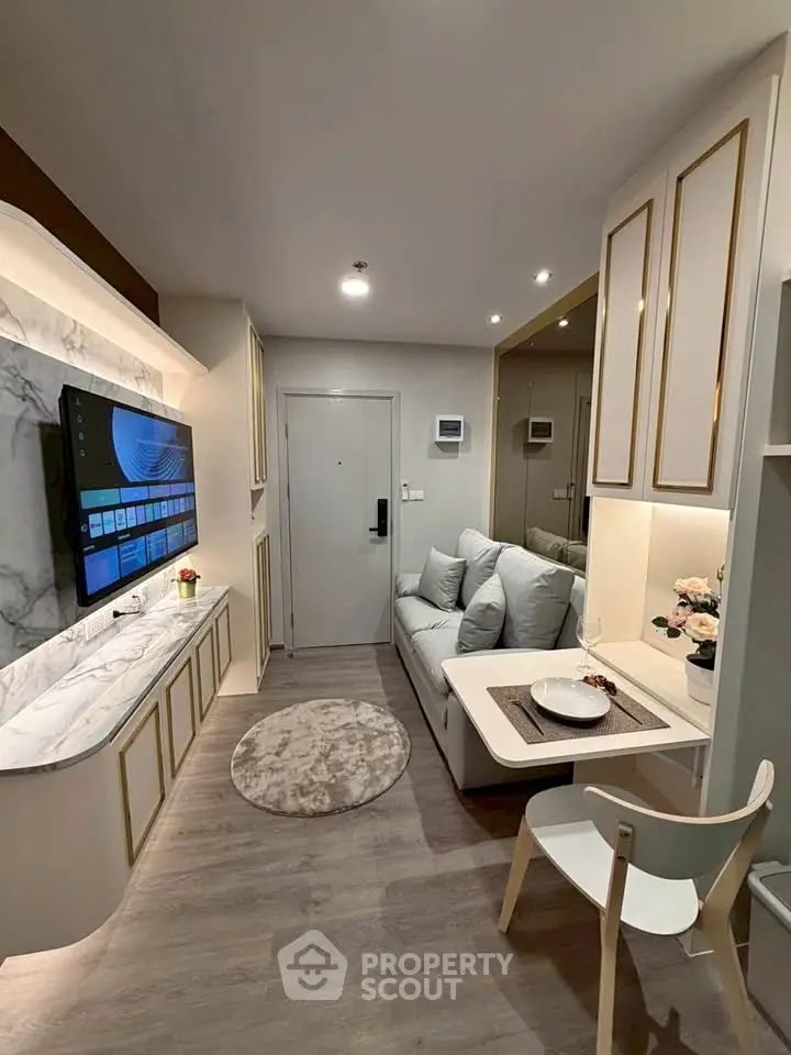 Modern living room with sleek design, marble accents, and cozy seating in a compact apartment.