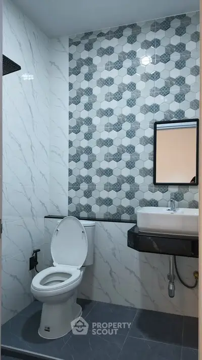 Modern bathroom with stylish hexagonal tile design and sleek fixtures.