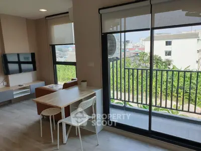 Modern living room with balcony view and stylish furniture in a bright apartment.
