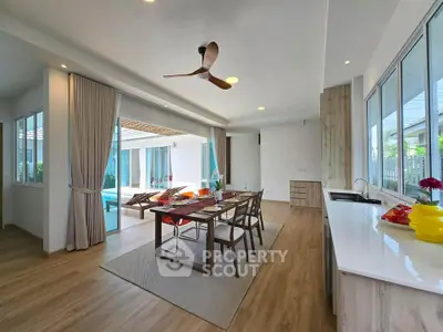Spacious open-plan dining area with pool view and modern decor