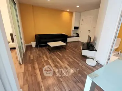 Modern living room with wooden flooring and sleek furniture in a contemporary apartment.