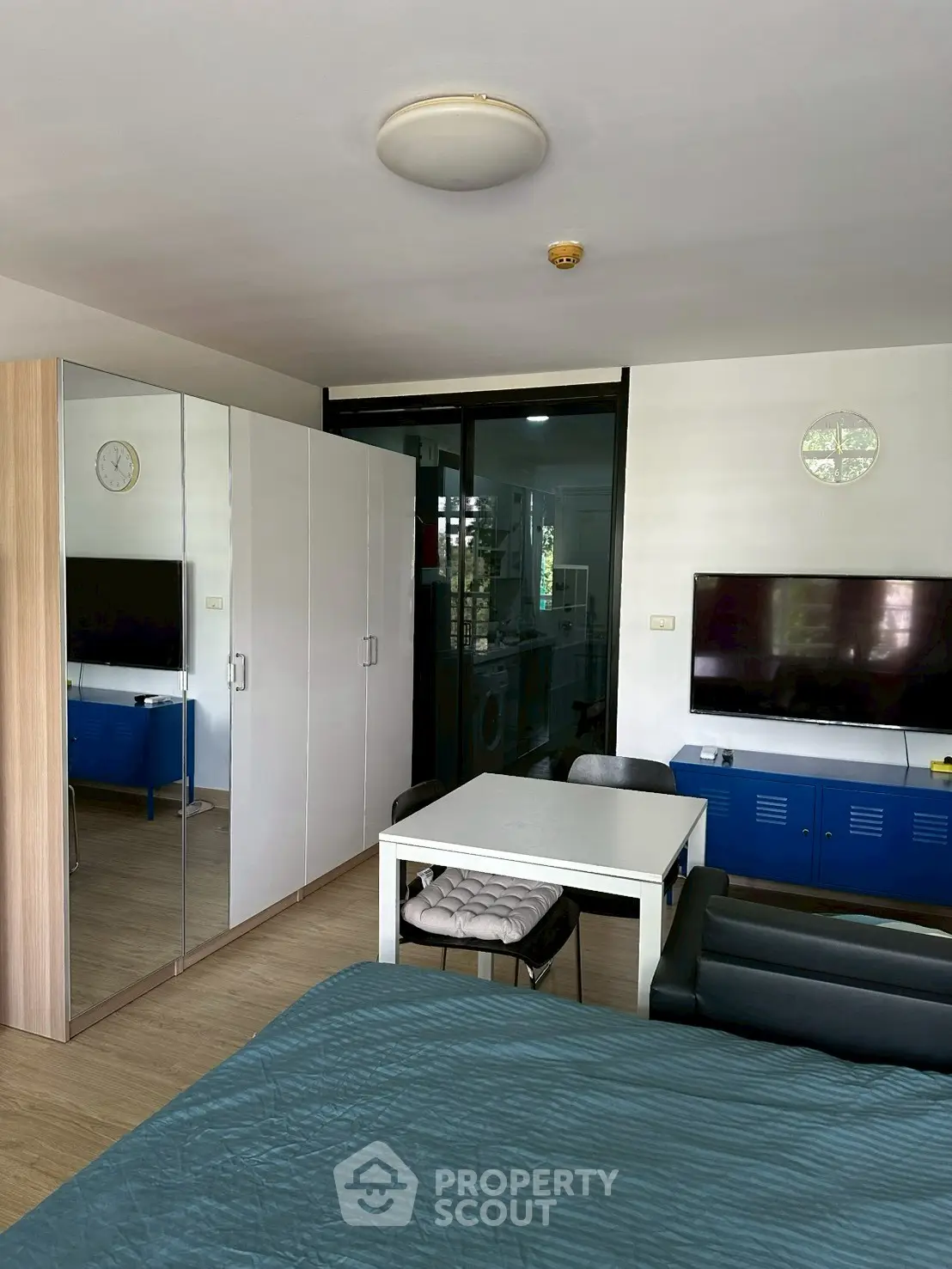 Modern studio apartment with sleek furnishings and mirrored wardrobe