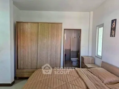 Cozy bedroom with wooden wardrobe and ensuite bathroom in modern apartment