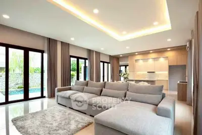 Luxurious open-plan living room with large sofa and pool view, perfect for modern family living.