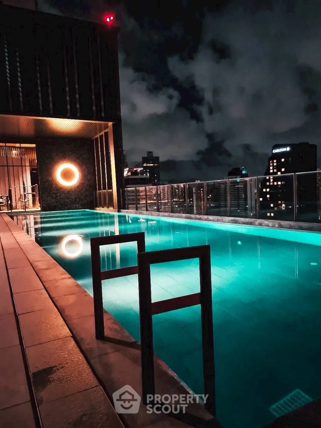 Luxurious rooftop pool with stunning city skyline view at night