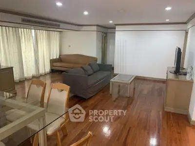 Spacious living room with wooden flooring and modern furniture in a stylish apartment.