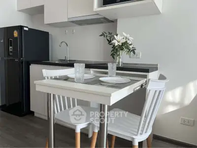 Modern kitchen with sleek design, featuring compact dining area and stylish appliances.