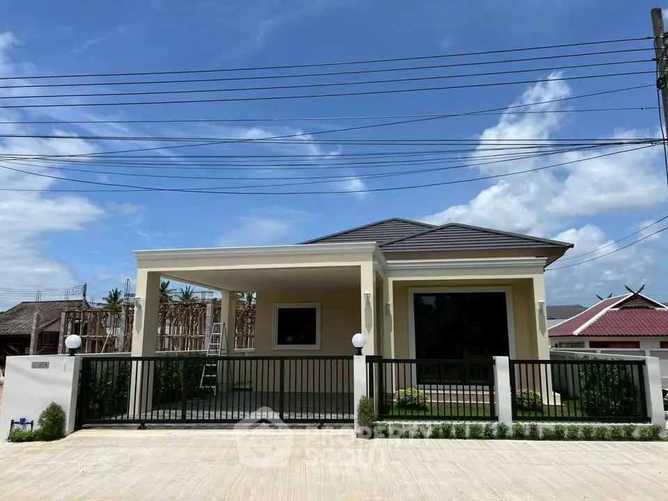 Charming single-story home with modern design and spacious driveway under clear blue skies.