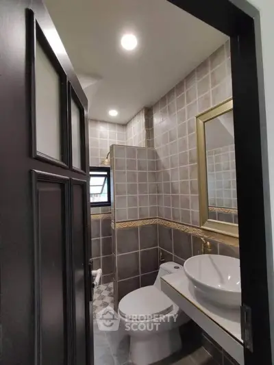 Modern bathroom with stylish tiles and elegant fixtures in a compact space.