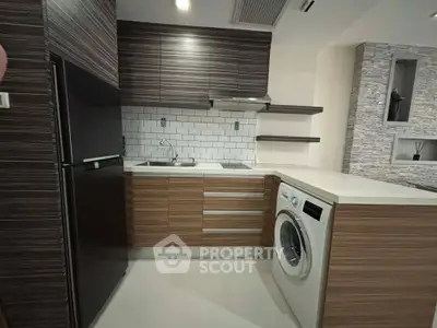 Modern kitchen with sleek cabinetry, integrated washing machine, and stylish backsplash.