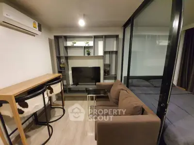 Modern living room with glass partition and stylish furniture in a cozy apartment.