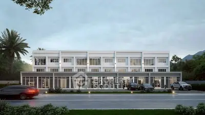 Modern commercial building with sleek design and ample parking space.