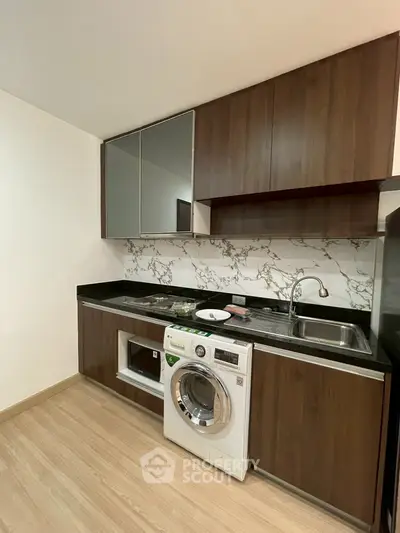 Modern kitchen with wooden cabinets and built-in washing machine