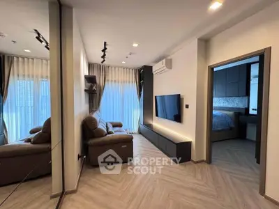Modern living room with sleek design and cozy seating, adjacent to a stylish bedroom.