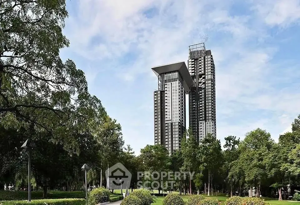 Stunning modern high-rise building with lush green surroundings and clear blue sky.