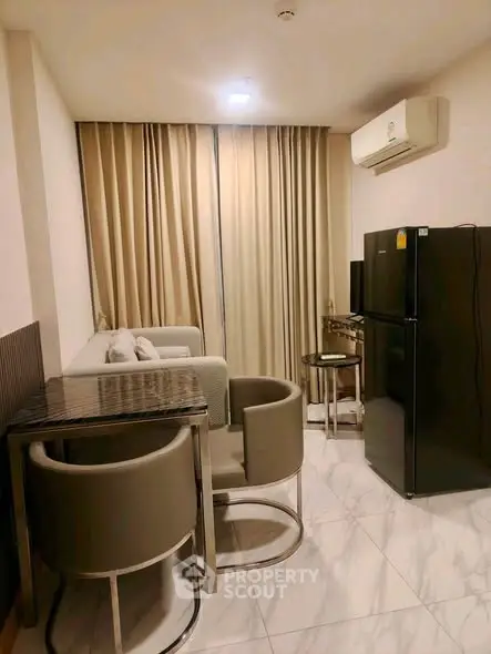 Modern living room with sleek furniture and appliances in a cozy apartment setting.