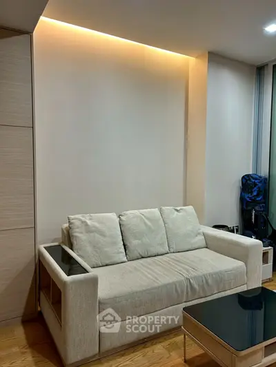 Modern living room with cozy beige sofa and sleek glass coffee table