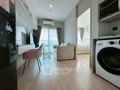 Modern apartment interior with open layout, featuring a cozy living area and in-unit washing machine.