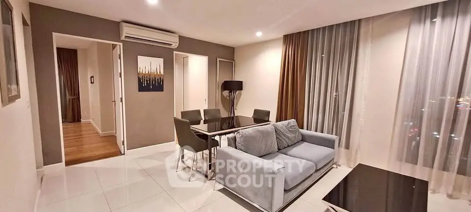Modern living room with elegant decor and city view, featuring a cozy sofa and dining area.