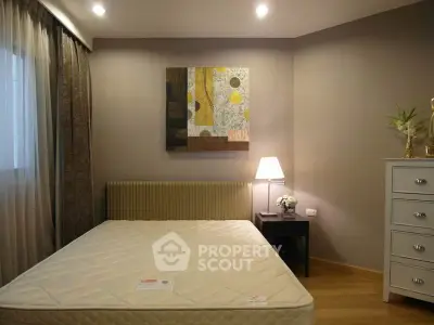 Cozy bedroom with modern decor, featuring a comfortable bed, stylish artwork, and ambient lighting.