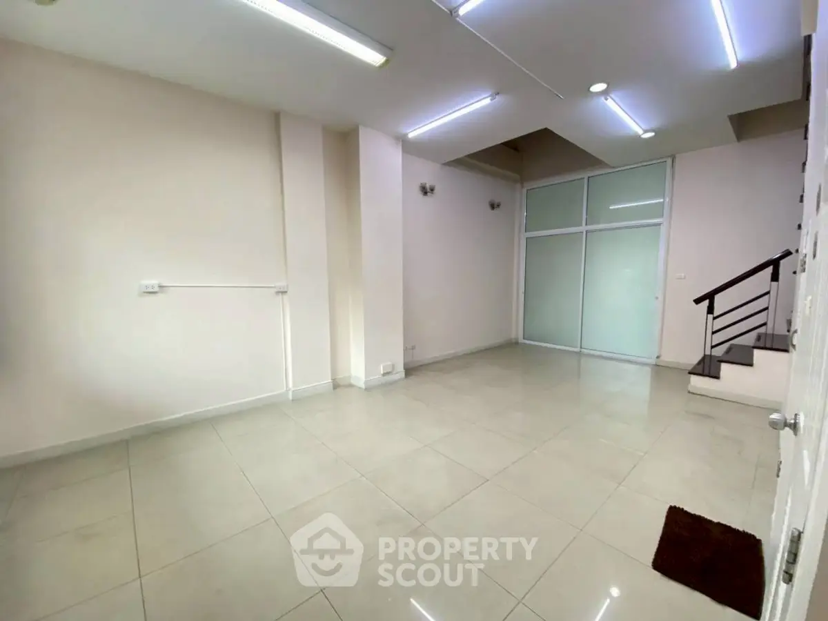 Spacious interior with modern lighting and tiled flooring, ideal for versatile use.