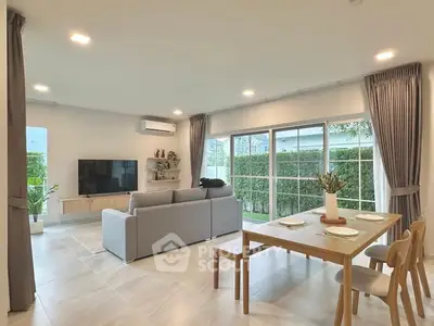 Spacious modern living room with large windows and elegant dining area.