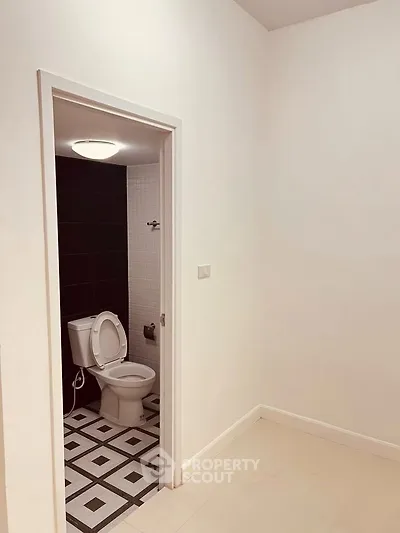 Minimalist bathroom with geometric floor tiles and modern fixtures.