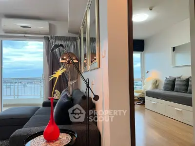 Modern living room with balcony view and stylish decor in a high-rise apartment.