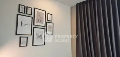 Stylish modern living room with elegant wall art and floor-to-ceiling curtains.