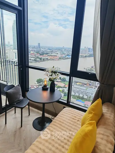 Stunning high-rise bedroom with panoramic river view and cozy decor.