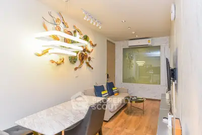 Modern living room with stylish decor and cozy seating area, featuring elegant lighting and wooden flooring.