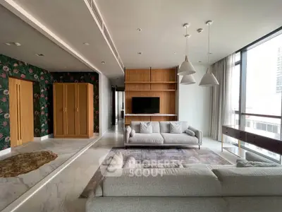 Spacious modern living room with stylish decor and large windows offering natural light.