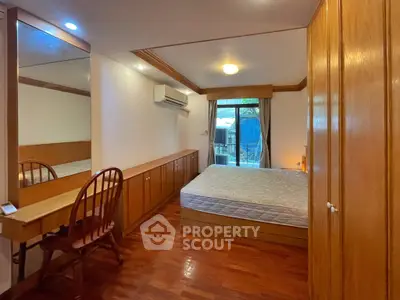 Cozy bedroom with wooden furniture and large window overlooking garden