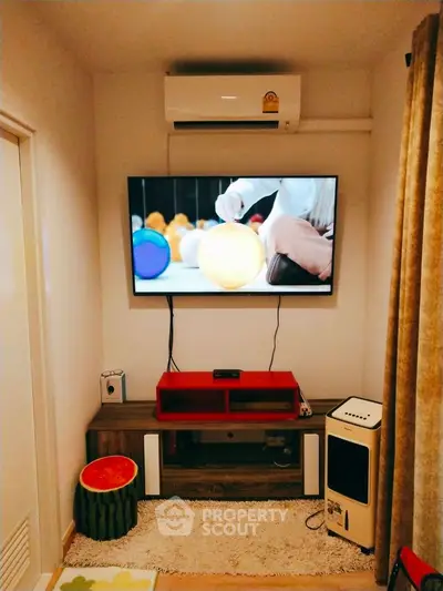 Cozy living room with wall-mounted TV and air conditioning unit, perfect for relaxation.