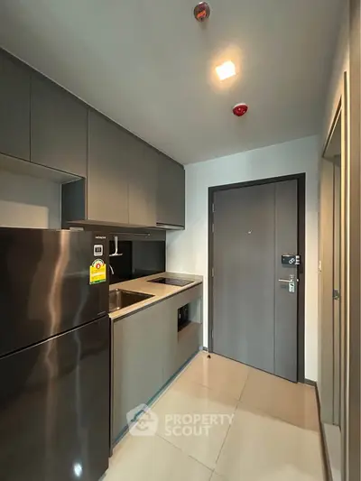 Modern compact kitchen with sleek cabinetry and stainless steel appliances